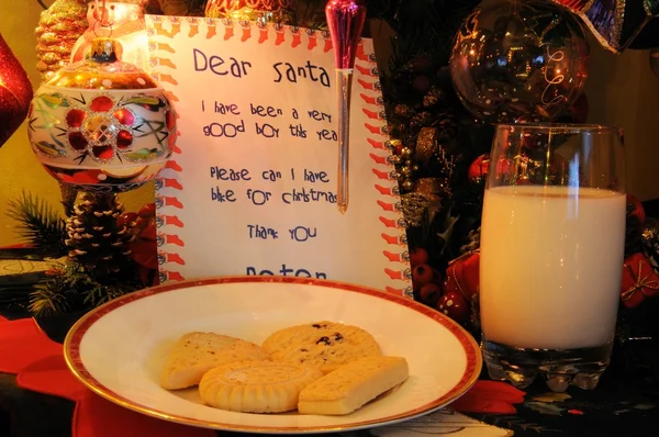 Dear Santa letter, milk and cookies under Christmas tree.