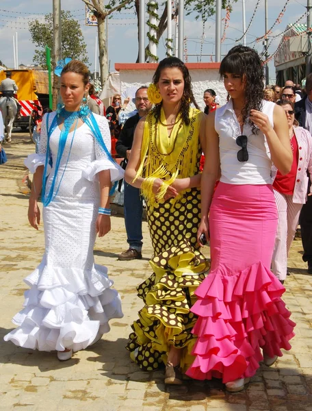 Three women walking along the street in traditional dress at the Seville Fair, Seville. — Stock Photo, Image