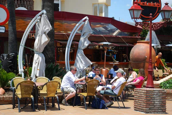 Turistas relajándose en una cafetería en la zona portuaria, Benalmádena . — Foto de Stock