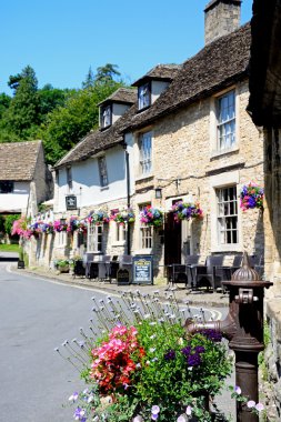 Eski su pompası ve çiçekler arka, Castle Combe Castle Inn wth.