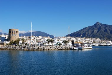 Soldaki gözetleme kulesi ile liman girişi ve arkada La Concha dağı, Puerto Banus, Marbella.