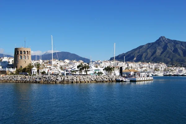 Wejście do portu z wieży strażniczej w lewo i góry La Concha do tyłu, Puerto Banus, Marbella. — Zdjęcie stockowe