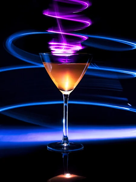 Colorful cocktail in glass with light effects on dark background. — Stock Photo, Image