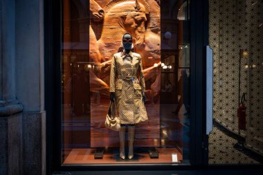 Milan, İtalya - 2026, 13 Ocak: Gucci FW25 vitrininde, çarpıcı bir görsel etki için zarif bir binicilik zeminine karşı dizilmiş altın desenli bir ceket ve aksesuarlar yer almaktadır.