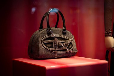 Milan, İtalya - 2026, 13 Ocak: Zarif Diesel FW25 el çantası lüks tasarım ve modern İtalyan moda eğilimlerini ön plana çıkaran parlak kırmızı bir kaidede sergilendi