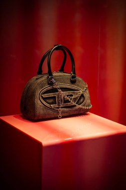 Milan, İtalya - 2026, 13 Ocak: Sleek Diesel FW25 siyah el çantası lüks tasarımı ve çağdaş İtalyan moda tarzında kırmızı kaidede sergilendi