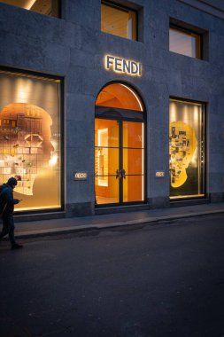 Milan, İtalya - 2026, 13 Ocak: Şık Fendi mağazası alacakaranlıkta parlıyor, modern, şık bir şehir caddesinde FW25 lüks moda sergiliyor.