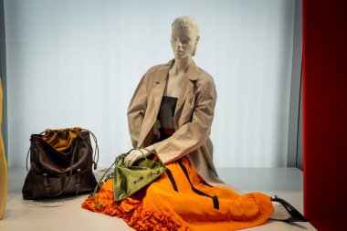 Milan, İtalya - 2026, 13 Ocak: Prada FW25 sergisi modern İtalyan moda eğilimlerini vurgulayan kalın turuncu etekli, tasarımcı ceketli ve lüks çantalı şık bir mankene yer alıyor.