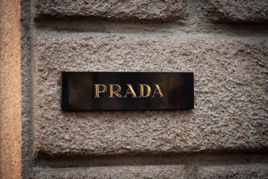 Milan, İtalya - 2026, 13 Ocak: Dokulu taş duvardaki zarif Prada butik tabelası lüks markalaşma ve sofistike FW25 moda cazibesini vurguluyor