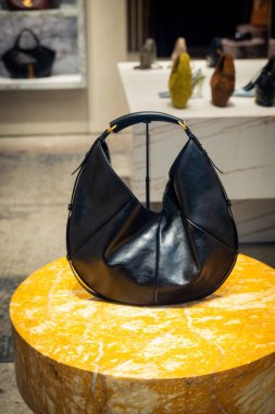 Milan, İtalya - 2026, 13 Ocak: Pürüzsüz Saint Laurent FW25 siyah deri çanta mermer üzerinde sergileniyor, lüks işçilik ve modern İtalyan tarzı