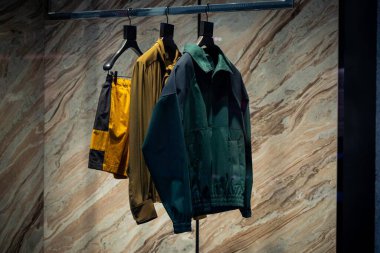 Milan, İtalya - 2026, 13 Ocak: Zarif Saint Laurent FW25 sergisi, lüks moda eğilimlerini vurgulayarak mermer bir zemin karşısında yeşil bir ceket ve altın şort yer alıyor