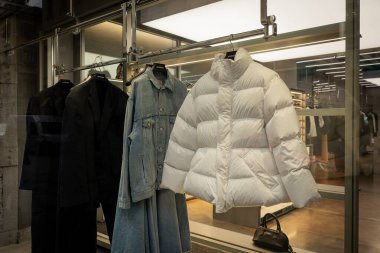 Milan, İtalya - 2026, 3 Şubat: Balenciaga FW25 vitrininde beyaz bir kabarık ceket ve kot ceket, modern lüks moda eğilimlerini vurguluyor