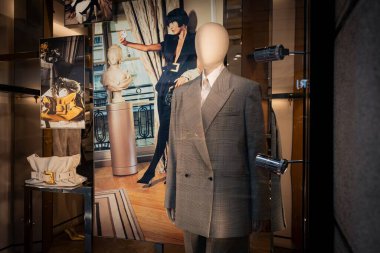 Milan, İtalya - 2026, 3 Şubat: Ekose bir takım elbise, şık aksesuarlar ve lüks bir moda butiğinde cesur görsel pazarlama içeren Balmain FW25 mağaza penceresi