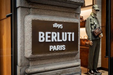 Milan, İtalya - 2026, 3 Şubat: Berluti FW25 mağazasının vitrininde sofistike erkek giyim, lüks aksesuarlar ve kaliteli bir butik mağazada şık şehir tarzı yer alıyor