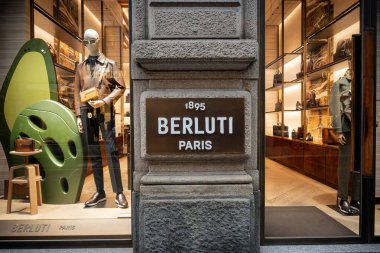 Milan, İtalya - 2026, 3 Şubat: Berluti FW25 koleksiyonu lüks moda, modern tasarım ve premium aksesuarları ön plana çıkarak şık bir mağaza vitrininde sergilendi