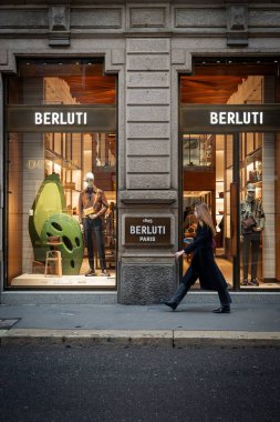 Milan, İtalya - 2026, 3 Şubat: Berluti FW25 vitrininde modern Milan butik ortamında lüks erkek giyim ve aksesuarları sergileniyor