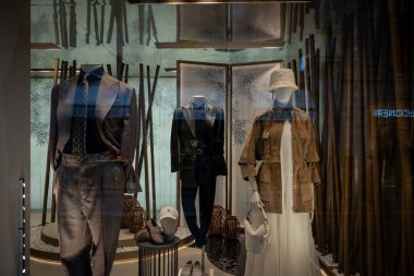 Milan, İtalya - 2026, 3 Şubat: Brunello Cuccinelli FW25 vitrininde sofistike, modern butik bir ortamda zarif, katmanlı kıyafetler ve rafine aksesuarlar sergilenmektedir.