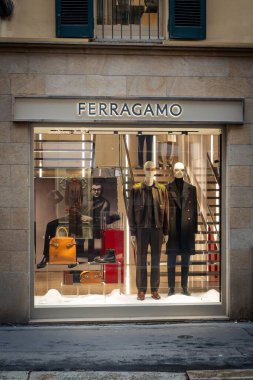 Milan, İtalya - 2026, 3 Şubat: Ferragamo FW25 butik vitrininde lüks erkek giyim, şık aksesuarlar ve şık bir şehir ortamında modern İtalyan zarafeti sergileniyor