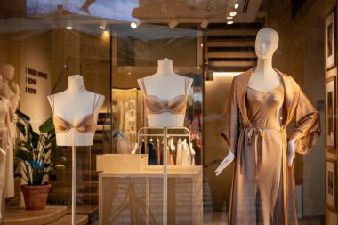 Milan, İtalya - 2026, 3 Şubat: Intimissimi FW25 butik vitrininde yumuşak altın tonlarda şık saten iç çamaşırı ve uyku giysisi sergileniyor, lüks ve çağdaş tarzı vurguluyor