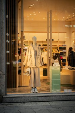 Milan, İtalya - 2026, 3 Şubat: Lacoste FW25 vitrininde modern lüks ve moda ileri tasarımını ön plana çıkaran şık, nötr renkli bir kıyafet ve şık aksesuarlar yer alıyor