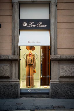 Milan, İtalya - 2026, 3 Şubat: Loro Piana FW25 butik vitrininde zarif bir İtalyan modası ve zarif bir şehir ortamında rafine edilmiş terzilik ve lüks İtalyan tarzını ön plana çıkaran şık bir kahverengi elbise yer alıyor.