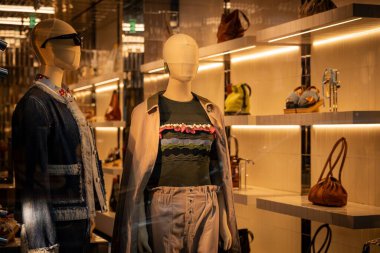Milan, İtalya - 2026, 3 Şubat: Marni FW25 vitrininde şık mankenler, tasarımcı kıyafetleri ve lüks el çantaları şık bir şekilde aydınlatılmış butik bir ortamda sergileniyor