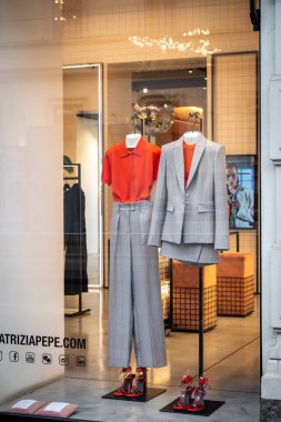 Milan, İtalya - 2026, 3 Şubat: Patrizia Pepe FW25 vitrininde modern zarafet ve İtalyan moda eğilimlerini vurgulayan şık turuncu ve gri kıyafetler sergileniyor