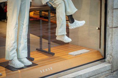 Milan, İtalya - 2026, 3 Şubat: Sease FW25 vitrininde lüks moda eğilimlerini vurgulayan gösterişli beyaz kıyafetler ve spor ayakkabıları içinde modern, şık mankenler yer alıyor