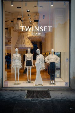 Milan, İtalya - 2026, 3 Şubat: Twinset FW25 butik vitrin vitrininde lüks bir perakende satış ortamında zarif beyaz kıyafetler, tüy ayrıntıları ve şık modern stil yer alıyor.