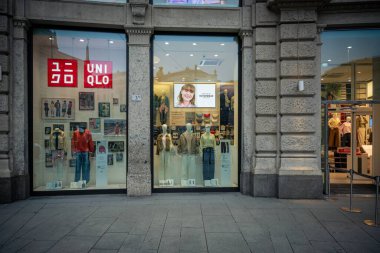 Milan, İtalya - 2026, 3 Şubat: Uniqlo FW25 mağaza vitrininde canlı bir şehir alışveriş bölgesinde modern moda vitrinleri ve şık pencere tasarımları yer alıyor