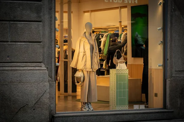 Milan, İtalya - 2026, 3 Şubat: Lacoste FW25 vitrininde lüks bir butik mağazada şık nötr renkler, modern tasarım ve prim aksesuarları sergileniyor