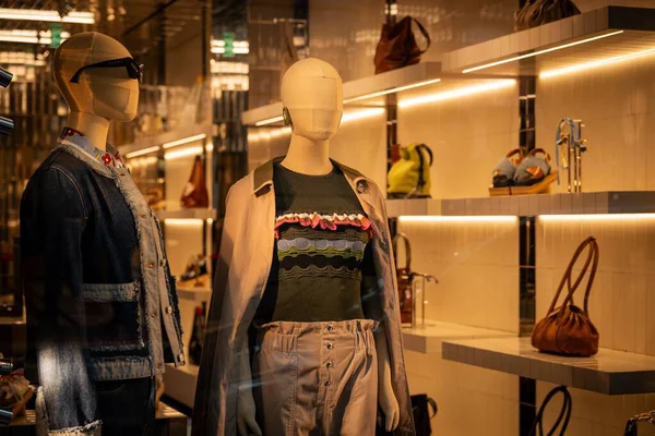 Milan, İtalya - 2026, 3 Şubat: Marni FW25 vitrininde şık mankenler, tasarımcı kıyafetleri ve lüks el çantaları şık bir şekilde aydınlatılmış butik bir ortamda sergileniyor