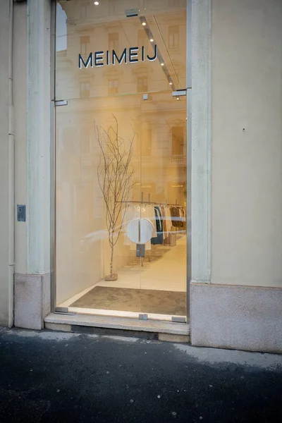 Milan, İtalya - 2026, 3 Şubat: Meimeij butik koleksiyonu minimalist cam mağaza önü, zarif iç mekan ve şık kentsel cazibe ile FW25 koleksiyonu sergiliyor