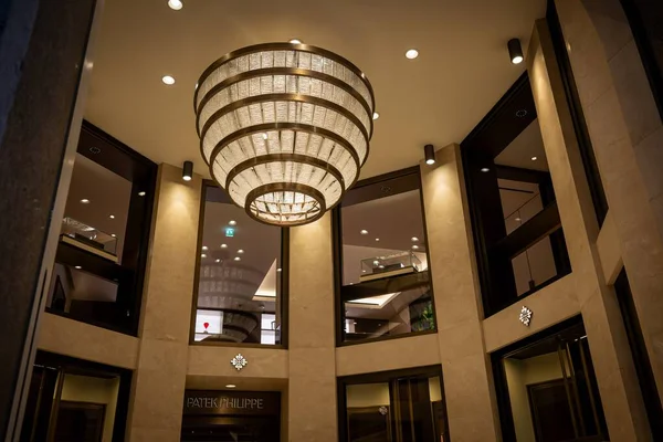 Milan, İtalya - 2026, 3 Şubat: Opulent Patek Philippe butik iç mimarisi büyük avize, mermer kaplama ve lüks bir FW25 vitrini için zarif mimari ayrıntılar