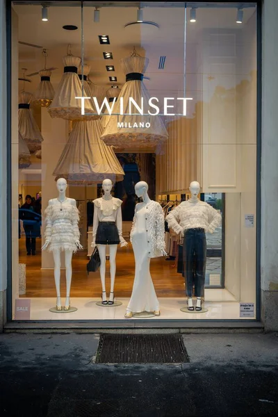 Milan, İtalya - 2026, 3 Şubat: Twinset FW25 butik vitrin vitrininde lüks bir perakende satış ortamında zarif beyaz kıyafetler, tüy ayrıntıları ve şık modern stil yer alıyor.