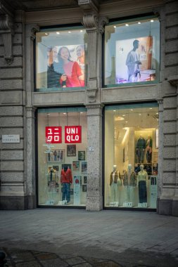 Milan, İtalya - 2026, 3 Şubat: Uniqlo FW25 mağaza vitrininde şık bir şehir ortamında şık mankenler, modern tasarım ve canlı moda eğilimleri yer alıyor