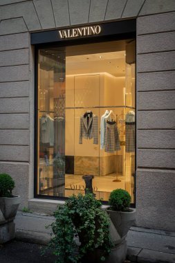 Milan, İtalya - 2026, 3 Şubat: Valentino FW25 butik vitrininde şık, aydınlık bir dekor, lüks ve modern tarzı yakalayan şık bir tasarımcı moda sergileniyor