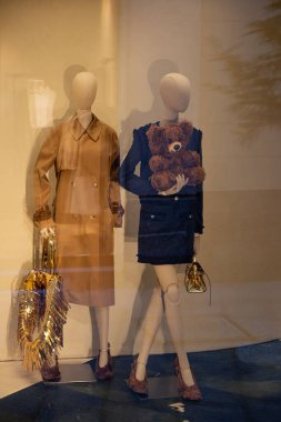 Milan, İtalya - 17 Şubat - Moschino SS26 vitrin vitrininde şık mankenler, oyuncak ayı çantası ve şık bir butik mağazada lüks altın aksanlar