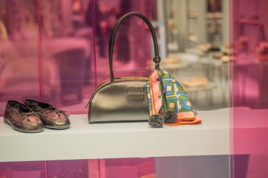 Milan, İtalya - 2026, 17 Şubat: MIU MIU SS26 vitrininde metalik bir çanta, şık ayakkabılar ve canlı atkı, lüks moda ve modern zarafeti ön plana çıkarıyor