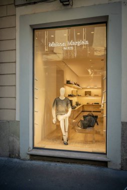 Milan, İtalya - 17 Şubat - Maison Margiela SS26 butik vitrininde şık bir şehir ortamında minimalist zarafet, lüks aksesuarlar ve modern tasarım sergileniyor