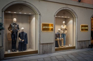 Milan, İtalya - 17 Şubat - Jacob Cohen SS26 vitrin vitrininde lüks kot ve şık kıyafetlerle tasarlanmış zarif, modern mankenler yer alıyor.