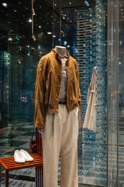 Milan, İtalya - 17 Şubat 2026: Giorgio Armani SS26 erkek giyim sergisi süet ceket, bej pantolon ve şık, modern butik bir ortamda beyaz spor ayakkabılar