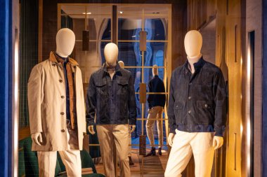 Milan, İtalya - 17 Şubat - Zarif FAY SS26 erkek giyim vitrininde modern ceketler, nötr renkler ve lüks bir butik mağazada sofistike şehir tarzı sergileniyor