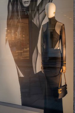 Milan, İtalya - 17 Şubat - Elisabetta Franchi SS26 vitrininde şık bir siyah elbise, altın aksanlar ve lüks bir butik mağazada modern bir zarafet sergileniyor