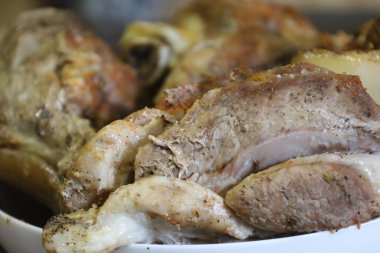 Grilled pork slices with a golden-brown crust and aromatic spices, served on a white plate.