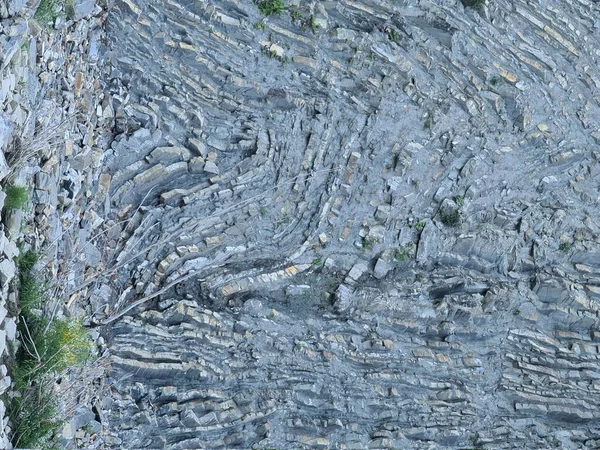 Taş dokusu ve kıvrımlı katmanlar.