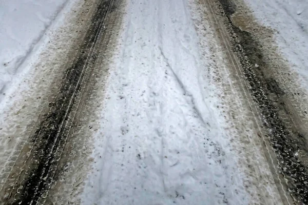 Snow covered road and car tire tracks in winter