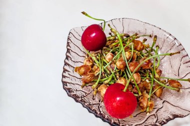 Olgun kırmızı kirazlar ve bir tabakta kiraz tohumları..