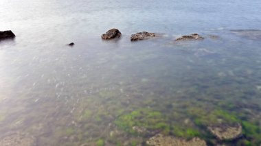 Uzun pozlama. Deniz kenarındaki kayalıklar ve deniz manzarası.