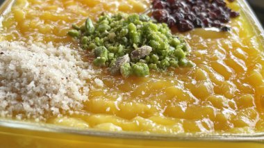 Geleneksel Türk tatlısının yanında rendelenmiş fıstık, hindistan cevizi ve kuru üzüm.. 